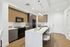 Modern kitchen featuring sleek wooden cabinets, a stylish breakfast bar, and stainless steel appliances.