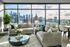Luxurious living room with modern sofas, elegant coffee table, and breathtaking skyline view from floor-to-ceiling windows.