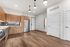 Modern kitchen with sleek wooden cabinetry, stainless steel appliances, and elegant lighting in a stylish open floor plan.