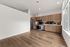 Modern apartment kitchen with sleek stainless steel appliances, elegant wood cabinetry, and ample natural light.