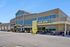 Bright and modern Harvest Market exterior with welcoming entrance and vibrant 'Now Open' signage.