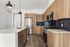 Modern kitchen showcasing sleek wooden cabinetry, stainless steel appliances, and elegant pendant lighting.