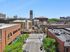 Vibrant urban scene featuring the iconic State Theatre, surrounded by charming brick buildings and lush greenery on a sunny day.