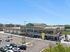 Vibrant shopping plaza featuring the spacious Harvest Market, ample parking, and inviting green spaces, perfect for community gatherings.