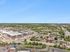 Aerial view showcasing a vibrant community with modern apartment complexes, lush greenery, and ample parking in a serene suburban setting.