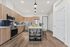 Elegant modern kitchen with wooden cabinetry, sleek stainless steel appliances, and a chic island bar with pendant lighting.