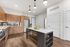 Modern and stylish kitchen featuring sleek wooden cabinetry, stainless steel appliances, and a spacious island illuminated by chic pendant lighting.