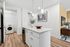 Modern apartment kitchen with sleek white cabinetry, elegant pendant lighting, and a convenient in-unit washer. Bright, inviting decor with stylish accents.
