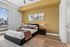 Bright and modern bedroom with stylish decor, featuring a cozy bed, elegant lighting, and cityscape view from the window.