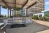 Elegant outdoor grilling area with sleek stainless steel barbecue surrounded by lush greenery and stunning cityscape views.