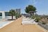 Luxurious rooftop pool area with modern lounge chairs, vibrant greenery, and stunning cityscape views.