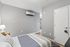Modern bedroom with cozy bedding, soft lighting, and sleek gray walls, offering comfort and style.