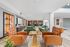 Luxurious communal lounge featuring elegant leather chairs, modern green sofas, and a chic chess table, creating a welcoming and stylish atmosphere.