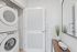Chic laundry area with stacked washer and dryer, complemented by elegant decor and modern finishes.