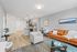 Contemporary open-concept living room with sleek kitchen, modern dining area, and a cozy orange sofa.