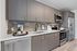 Modern kitchen with sleek gray cabinets, stainless steel appliances, and elegant marble countertops.