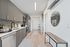 Modern kitchen in sleek apartment featuring stainless steel appliances, elegant cabinetry, and stylish decor with a minimalist touch.
