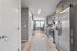 Modern kitchen with sleek stainless steel appliances, stylish cabinets, and cozy dining area overlooking a bright window.
