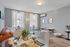 Bright and inviting living room with a large window, modern furnishings, and a cozy atmosphere, perfect for relaxation.