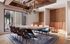 Sophisticated dining room with a modern chandelier, vibrant upholstered chairs, and floor-to-ceiling windows offering a bright, open ambiance.