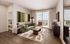 Bright and inviting living room with modern decor, featuring a plush green sofa, abstract art, and large windows for natural light.