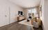 Chic living room with modern decor, featuring a sleek TV setup, stylish furniture, and large windows providing natural light.