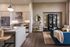 Modern living and kitchen area featuring sleek cabinetry, stainless steel appliances, and cozy seating with stylish decor.
