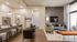 Modern open-concept living area featuring stylish kitchen with bar seating, elegant dining space, and cozy lounge with chic decor.