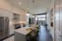 Elegant open-concept kitchen with sleek appliances, large island with seating, and expansive windows offering natural light and scenic views.