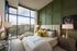 Elegant bedroom with large windows, offering a scenic view, featuring modern decor and luxurious bed linens.
