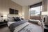 Elegant bedroom with large window offering a stunning urban view, modern decor, and cozy bed with plush bedding.