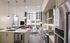 Modern open-plan kitchen and living area with sleek appliances, large windows, and chic decor.