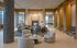 Elegant apartment lounge with plush seating, modern fireplace, and natural lighting showcasing a blend of luxury and comfort.