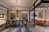 Elegant office space featuring modern furniture, a stylish chandelier, and a warm ambiance with glass partitions and wooden accents.