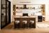 Stylish model kitchen with light oak cabinetry, a marble waterfall island with textured paneling, three boucl&eacute; bar stools with black metal bases, and sleek black appliances and range hood.