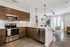 Modern Kitchen featuring wood-grain upper and lower cabinetry, stainless steel appliances and kitchen island with a white countertop