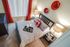 Contemporary bedroom with elegant decor features plush bedding, stylish red accents, and modern lighting.