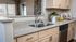 Elegant kitchen space featuring sleek granite countertops, double stainless steel sink, and modern cabinetry with a cozy, inviting ambiance.