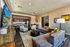 Luxurious open-concept living room and kitchen with modern decor, chic furniture, and vibrant artwork.