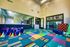 Vibrant kids play zone with colorful flooring, engaging play equipment, and cheerful wall decor.