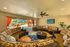 Luxurious open lounge area with cozy wicker seating, vibrant decor, and seamless access to outdoor amenities through large sliding doors.