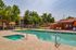 Inviting apartment community pool area featuring comfortable lounge chairs and lush greenery, perfect for relaxation and enjoyment.