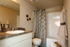 Modern bathroom with elegant decor, featuring a sleek countertop, contemporary fixtures, and stylish shower curtain.