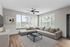 Bright and inviting living room with a modern sectional sofa, sleek coffee table, and large windows showcasing lush greenery.