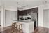 Modern kitchen with sleek dark cabinetry, stainless steel appliances, and elegant granite countertops, highlighted by stylish pendant lighting and a cozy island with wooden stools.