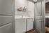 Modern in-unit laundry room with sleek washer and dryer set, featuring convenient shelving for storage.