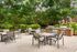 Charming outdoor patio area with stylish seating and modern grills surrounded by lush greenery.