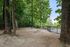 Inviting fenced outdoor space featuring tall lush trees and a serene atmosphere perfect for leisurely strolls.