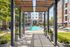 Inviting apartment complex entrance with a shimmering pool, vibrant landscaping, and modern architecture promising luxurious living.