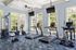 Bright and modern fitness center featuring state-of-the-art cardio machines and full-length windows for an energizing workout experience.